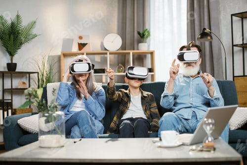 Preview: Charming teenage grandson with his grandmother and grandfather watching in vr headset