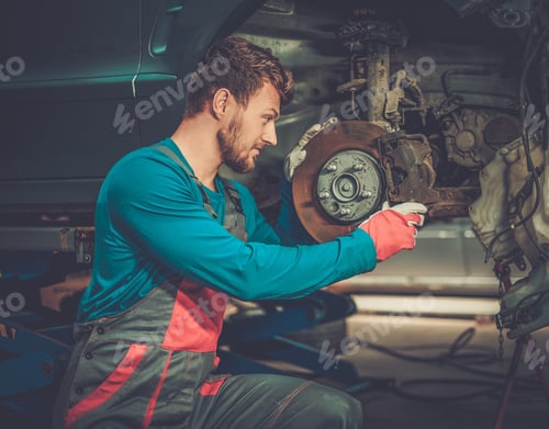Mechanic checking car brake system in a workshop