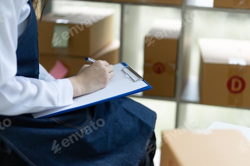 Preview: Businesswoman start-up online small business write records and check lists of orders and merchandise
