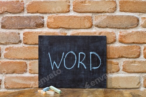 Preview: Chalk board with the word WORD drown by hand and chalks on wooden table on brick wall background.