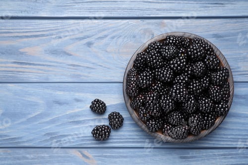 Preview: Fresh ripe blackberries on blue wooden table, flat lay. Space for text