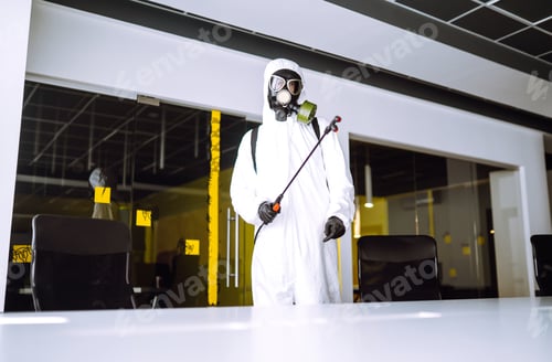 Preview: Disinfecting of office to prevent COVID-19, Man in protective hazmat suit with spray chemicals.