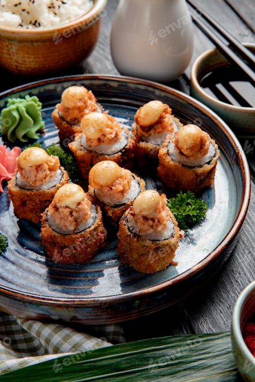 Preview: side view of baked sushi rolls with shrimps ginger and wasabi on a plate