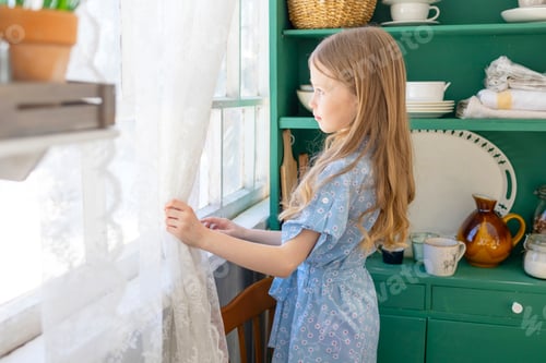 Preview: portrait little girl in blue dress stay near window on spring terrace