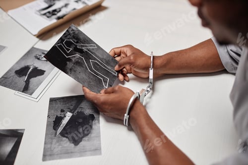 Preview: Man wearing handcuffs looking at evidence pictures during interrogation