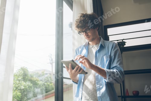 Preview: Business or creative man using digital tablet working at home