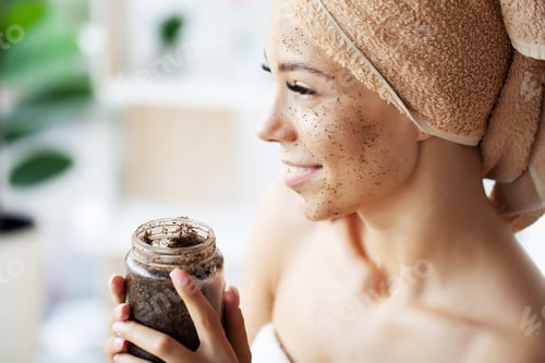 Preview: Young woman applying scrub on face in bathroom