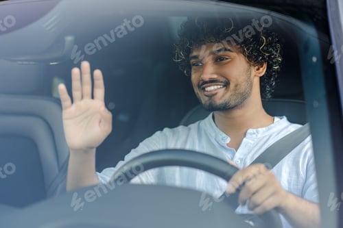 Preview: Young man is driving a car and waving to someone