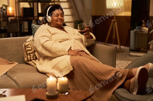 Preview: Woman Relaxes with Headphones and a Glass of Wine