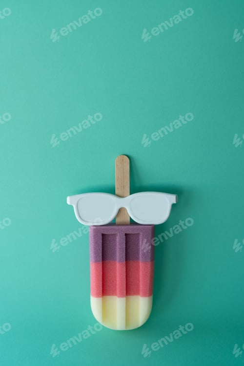 Preview: Colored popsicle with glasses on mint background. Minimal summer concept.