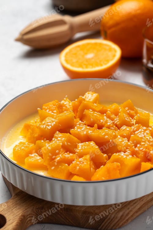 Preview: Healthy dessert with sliced pumpkin, honey and orange juice in a bowl. Healthy pumpkin dish.