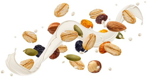 Preview: Falling muesli, oat granola with milk splash isolated on white background