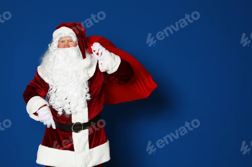 Preview: Happy authentic Santa Claus with bag full of gifts on blue background. Space for text