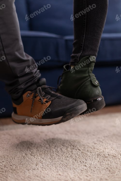 Preview: Happy cheerful friends touching feet keeping social distancing