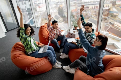 Vista previa: Employees putting hands in air while working in open office