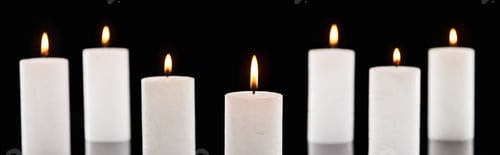 Preview: selective focus of burning white candles glowing isolated on black, panoramic shot