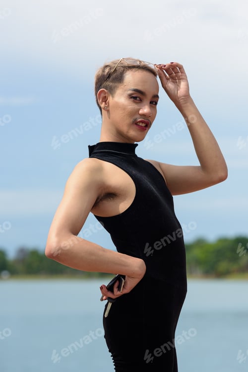 Preview: Beautiful Asian queer LGBT community supporter man with mustache wearing lipstick and jumpsuit
