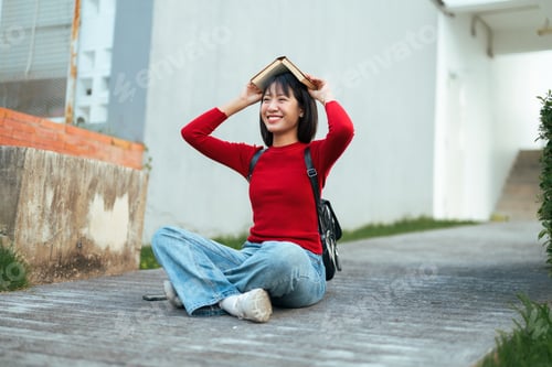 Preview: Smiling Woman with Book Outdoors in Urban Setting