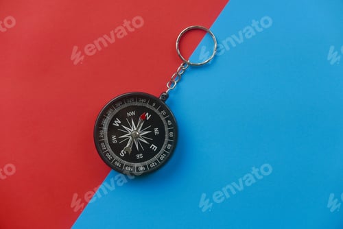 Preview: Top view of black compass on two color background which are red and blue.