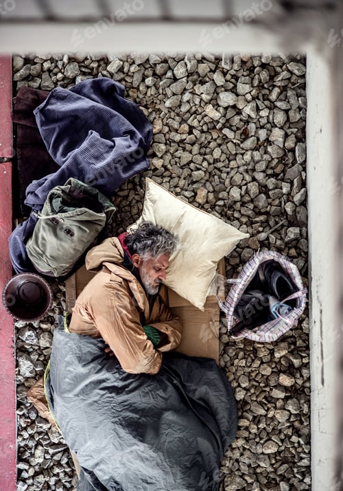 Preview: A top view of homeless beggar man lying on the ground outdoors in city, sleeping.