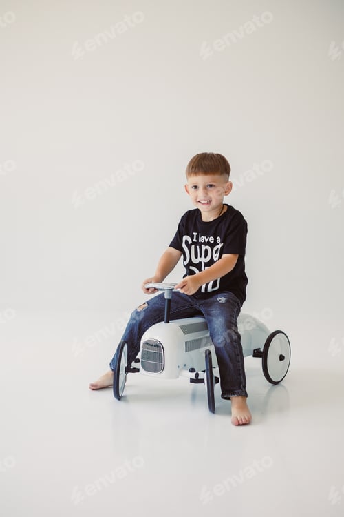 Preview: A Playful Child Enjoys Riding a Colorful Toy Tractor Inside a Bright and Fun Studio Space