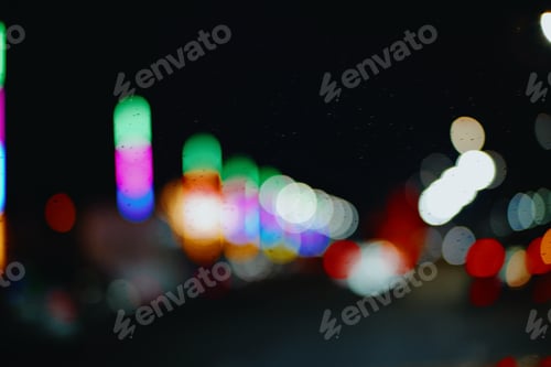 Preview: Abstract blur lights night in the city background. Rain drop on the windshield, Bokeh of traffic lig