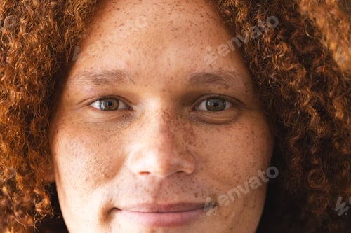 Preview: Portrait of happy biracial man with curly red hair and freckles smiling