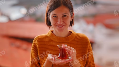 Preview: Woman drinking turkish tea from traditional turkish teacup