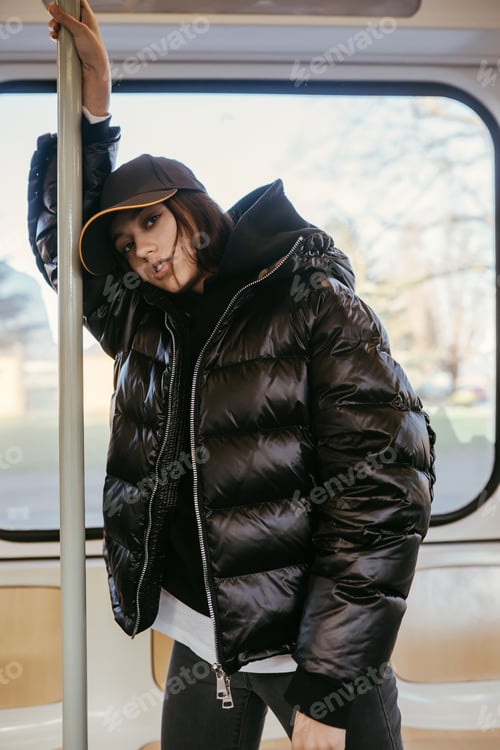 Preview: Young woman stands on the background of a window in public transport