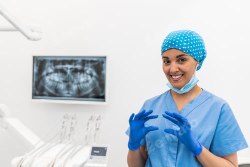 Preview: Dental hygienist smiling while holding a retainer during an orthodontic consultation in a clinic.