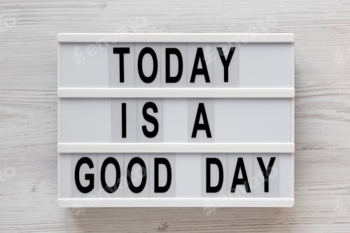 Preview: 'Today is a good day' words on a lightbox on a white wooden background, top view.