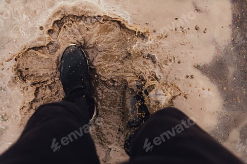 Preview: Crop person standing in splashing mud