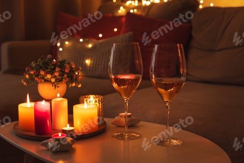 Preview: Cozy evening scene with candles, wine glasses and warm lighting.