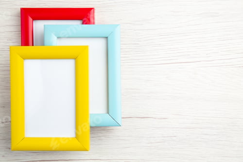 Preview: Top view of three empty picture frames in different colours on the right side on stripped background
