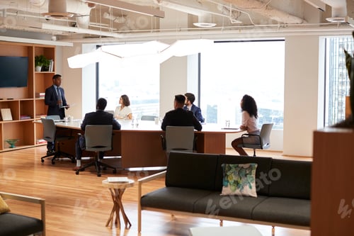 Preview: Group Of Business Professionals Meeting Around Table In Modern Office