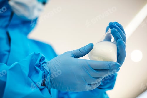 Preview: Female lab scientist examining samples in a test tube, working in an african american woman