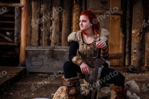 Preview: Red-haired woman is a Viking. Against backdrop of a village or an ancient settlement