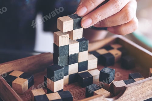 Preview: Closeup image of people playing and building wooden puzzle game