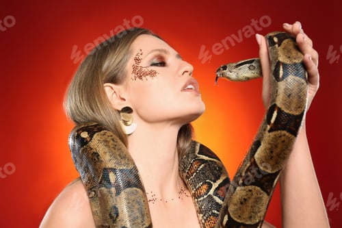 Preview: Beautiful woman with boa constrictor on bright colorful background