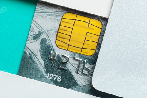 Preview: Bank card with chip shown partially behind an envelope on a flat surface