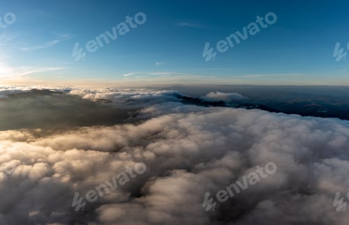 Preview: Thick layer of white clouds above road on mountain ridge