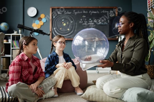 Preview: Young Adult Black Woman Teaching Two Caucasian Girls About Astronomy