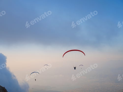 Preview: Paragliding in sky. Paraglider tandem flying over sea and mountains