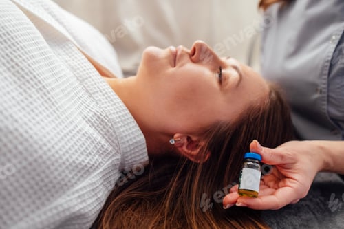 Preview: A close-up of a cosmetologist hand with a mock-up of a glass bottle with peeling liquid