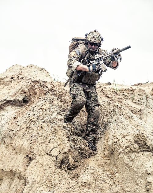 Preview: Army ranger with arms running down from sand dune