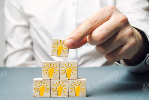 Preview: A businessman puts wooden blocks with a light bulb of an idea or inspiration