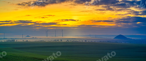 Preview: Turbines in a wind farm during a beautiful orange sunset in Sangerhausen, Germany