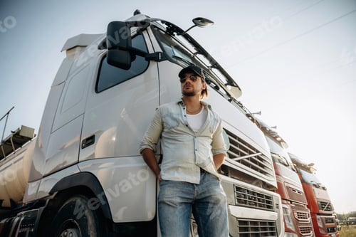 Preview: View from below, standing and posing. Truck driver is near the transport outdoors