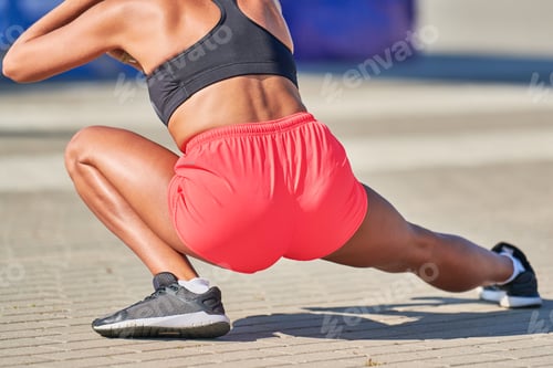 Preview: Young woman warming up before running marathon