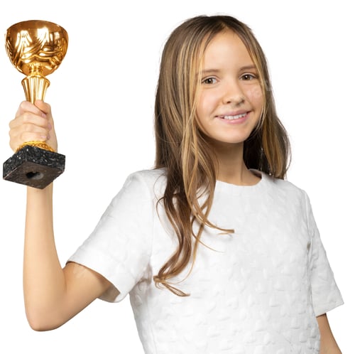 Preview: Girl smiles while holding a trophy in celebration after winning an event